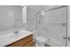 Clean, white bathroom with shower and glass door, vanity, mirror, toilet and storage cabinet above toilet at 7707 W Diablo Dr, Las Vegas, NV 89113