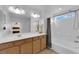 Bright bathroom featuring double sinks, neutral tile flooring, and a shower-tub combo at 7707 W Diablo Dr, Las Vegas, NV 89113