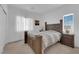 Bright bedroom features wood bed frame, two side tables with lamps, and a window with blinds and curtains at 7707 W Diablo Dr, Las Vegas, NV 89113