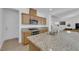 Open-concept kitchen and living room features stainless appliances, granite countertops, and wood cabinets at 7707 W Diablo Dr, Las Vegas, NV 89113