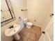 Compact bathroom featuring a pedestal sink, toilet, and tiled floors at 7948 Calico Vista Blvd # 101, Las Vegas, NV 89128