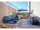 Inviting backyard with lounge seating, a grill, desert landscaping, and a blue umbrella at 8175 Caldera Creek St, Las Vegas, NV 89113