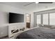 Spacious main bedroom with white dresser, TV, plantation shutters, and a view into the bathroom at 8175 Caldera Creek St, Las Vegas, NV 89113