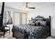 This bedroom features a ceiling fan, plantation shutters, and modern décor for comfort at 8175 Caldera Creek St, Las Vegas, NV 89113