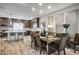 Open-concept dining area featuring wood floors, modern lighting, and a view into the adjacent kitchen at 8175 Caldera Creek St, Las Vegas, NV 89113