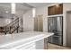 Bright, modern kitchen with stainless steel refrigerator and large island and pendant lights at 8175 Caldera Creek St, Las Vegas, NV 89113