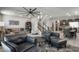 Open concept living room featuring modern furnishings including leather seating, staircase, kitchen, and dining area at 8175 Caldera Creek St, Las Vegas, NV 89113