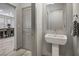 Stylish powder room with a modern pedestal sink and view of the dining room at 8175 Caldera Creek St, Las Vegas, NV 89113