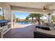 Covered outdoor living space with a barbecue and furniture overlooking the pool and lush landscaping at 8290 Gagnier Blvd, Las Vegas, NV 89113