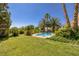 This backyard features lush landscaping, a pool, and a well-manicured lawn at 8290 Gagnier Blvd, Las Vegas, NV 89113