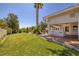 This backyard features lush landscaping, a covered patio, and a well-manicured lawn at 8290 Gagnier Blvd, Las Vegas, NV 89113
