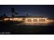 Stately one-story house with three-car garage and desert landscaping illuminated at night is welcoming to all at 8290 Gagnier Blvd, Las Vegas, NV 89113
