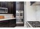 Modern kitchen with dark wood cabinets, stainless steel appliances, and white marble countertops at 8290 Gagnier Blvd, Las Vegas, NV 89113