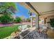 Covered patio with comfortable outdoor seating, an area rug, and lush landscaping at 8813 Sundial Dr, Las Vegas, NV 89134