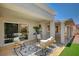 The covered patio offers a cozy seating area with wicker furniture and a modern outdoor rug at 8813 Sundial Dr, Las Vegas, NV 89134
