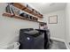 Laundry room features black washer and dryer with plenty of shelving for storage at 8820 Fall Green Ave, Las Vegas, NV 89129