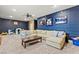 Large living room with carpet flooring, a sofa, and decorations displayed on navy blue walls at 8820 Fall Green Ave, Las Vegas, NV 89129