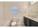 Well-lit bathroom featuring vanity, toilet, bathtub with tile surround and window at 9252 Oxbow Lake Ave, Las Vegas, NV 89149