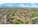 Extensive aerial view of the community featuring a golf course, tree-lined streets, and mountain views at 9424 Gold Mountain Dr, Las Vegas, NV 89134