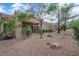 An angular view of a backyard with desert landscaping, a covered patio, and privacy fence at 9424 Gold Mountain Dr, Las Vegas, NV 89134