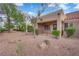 A view of a backyard featuring desert landscaping, a covered patio, and privacy fence at 9424 Gold Mountain Dr, Las Vegas, NV 89134