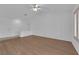 Bright living room with wood floors, a ceiling fan, large windows with shutters, and neutral walls at 9424 Gold Mountain Dr, Las Vegas, NV 89134