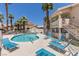 Community swimming pool with poolside furniture and desert landscaping at 1013 Falconhead Ln # 202, Las Vegas, NV 89128