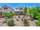 Home's backyard featuring desert landscaping, with rock features, shrubbery, and an inviting patio at 10312 Glimmering Star Dr, Las Vegas, NV 89178