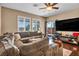 Cozy living room with a plush sectional sofa, fireplace, and sliding glass doors at 10312 Glimmering Star Dr, Las Vegas, NV 89178