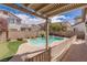 Inviting backyard oasis featuring a sparkling pool, lush landscaping, and cozy patio area for outdoor entertaining at 11484 Roncat Ct, Las Vegas, NV 89141