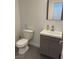 Well-lit half-bathroom with modern fixtures and gray wood grain vanity at 1525 Spiced Wine Ave # 14101, Henderson, NV 89074