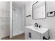 Clean bathroom featuring a walk-in shower, modern sink and fixtures, mirror, and minimalist shelves at 2 Utah Way, Henderson, NV 89015