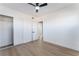Spacious bedroom with hardwood floors, sliding closet doors, white walls, and a modern ceiling fan at 2 Utah Way, Henderson, NV 89015