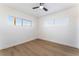 Bright bedroom featuring wood floors, base trim, white walls, and two windows letting in natural light at 2 Utah Way, Henderson, NV 89015