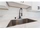 Modern kitchen sink featuring marble countertops, stylish faucet, and white cabinetry at 2 Utah Way, Henderson, NV 89015