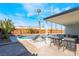 Backyard featuring a pool, patio seating area, palm trees, and a wooden fence providing privacy at 2 Utah Way, Henderson, NV 89015