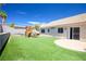 Large backyard with artificial grass, a playset, and a patio area perfect for outdoor entertaining at 218 Red Coral Dr, Henderson, NV 89002