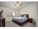 Cozy bedroom with neutral walls, carpet flooring, a queen bed with blue patterned bedding, and a ceiling fan at 218 Red Coral Dr, Henderson, NV 89002
