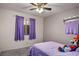 Comfortable bedroom with carpet flooring, a window with curtains, and a queen bed with a lavender comforter at 218 Red Coral Dr, Henderson, NV 89002