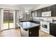 Well-lit kitchen with dark cabinets, center island, and stainless steel appliances at 218 Red Coral Dr, Henderson, NV 89002