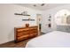 Bright bedroom showcasing a wooden dresser, ceiling fan, and doorway to an attached bathroom at 2200 S Fort Apache Rd # 2217, Las Vegas, NV 89117
