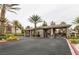 Gated entrance to the community with lush landscaping and mature palm trees on a cloudy day at 2200 S Fort Apache Rd # 2217, Las Vegas, NV 89117