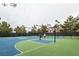 Community tennis and basketball court surrounded by trees and lights with residents playing at 2200 S Fort Apache Rd # 2217, Las Vegas, NV 89117