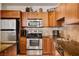 Updated kitchen features stainless steel appliances, warm wood cabinets, and stone tile backsplash at 2405 W Serene Ave # 612, Las Vegas, NV 89123
