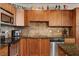 Charming kitchen with warm wood cabinetry, stainless steel appliances, and granite countertops at 2405 W Serene Ave # 612, Las Vegas, NV 89123
