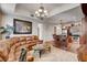 Comfortable living room with a large leather couch, chandelier, and open access to the kitchen at 2405 W Serene Ave # 612, Las Vegas, NV 89123
