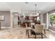 Open dining room featuring travertine floors, a modern chandelier, and large windows for ample natural light at 3085 Duneville St, Las Vegas, NV 89146