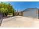 Spacious driveway leads to a home with a unique garage and mature landscaping, offering ample parking and curb appeal at 3085 Duneville St, Las Vegas, NV 89146