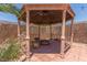 Backyard gazebo with a fire pit, decorative woodwork, and lush surrounding foliage at 3085 Duneville St, Las Vegas, NV 89146