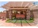 Outdoor hot tub in a covered space with stone pillars and artificial turf at 3085 Duneville St, Las Vegas, NV 89146